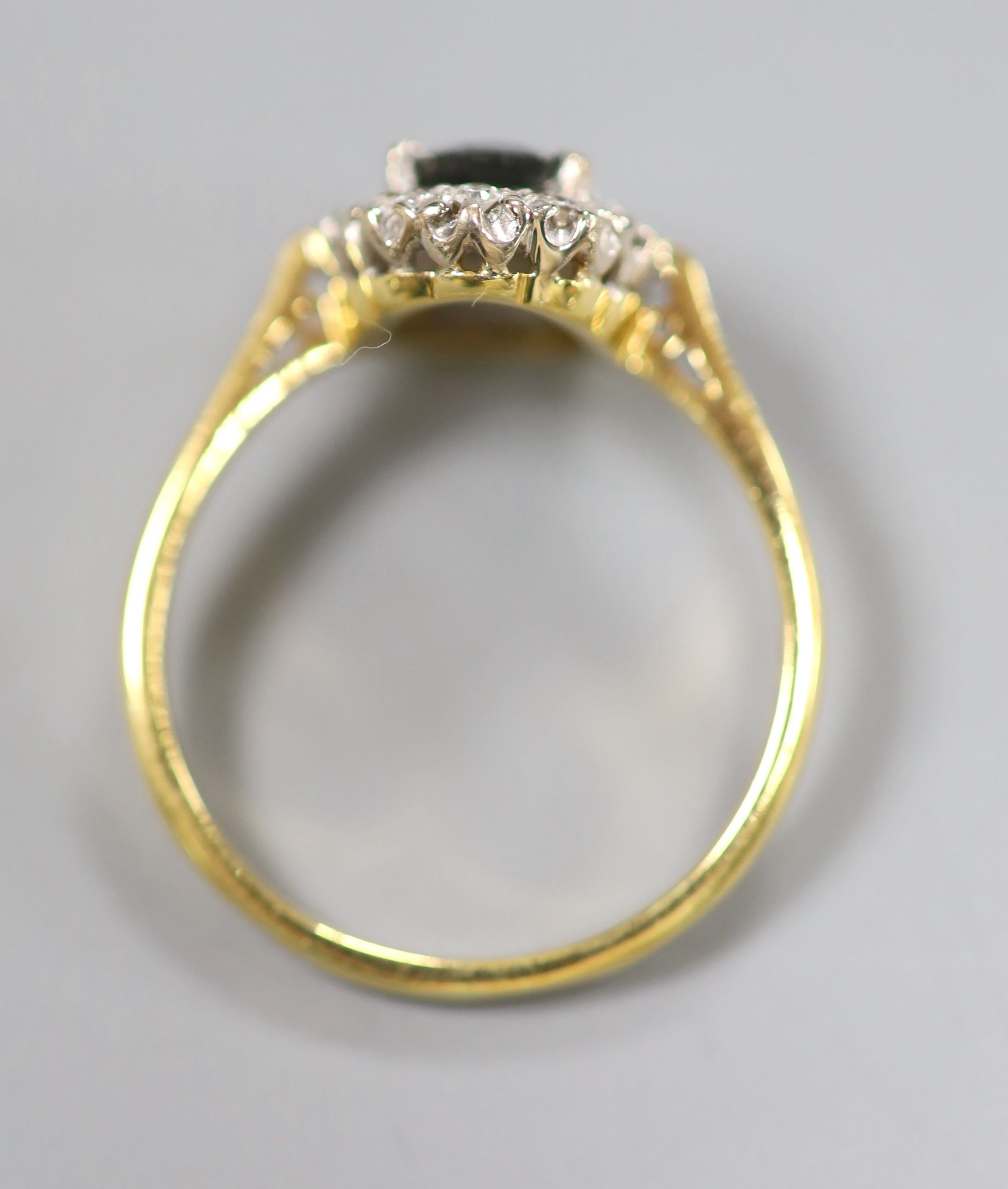 A modern 18ct gold, sapphire and diamond set oval cluster ring, size O, gross 3.2 grams.